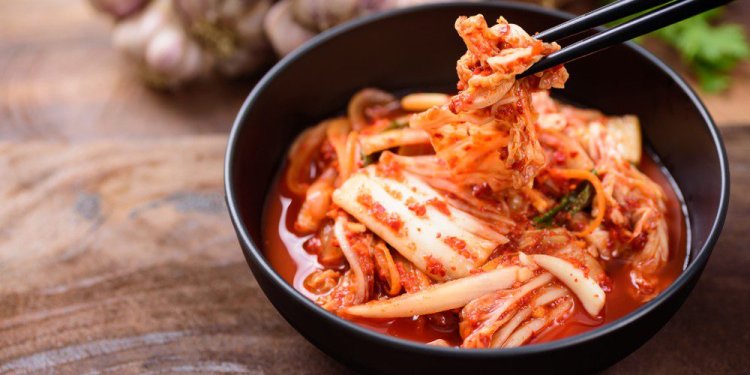 Eating,Kimchi,Cabbage,In,A,Bowl,With,Chopsticks,,Korean,Food