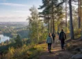 Žmonės eina miško taku su Vilniaus panorama tolumoje